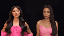two women are standing next to each other in pink dresses