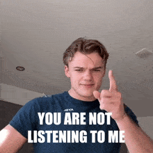 a man wearing a t-shirt that says " you are not listening to me " is giving the middle finger