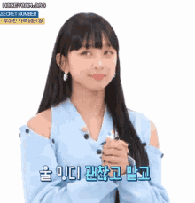 a girl with long black hair is wearing a blue top and earrings