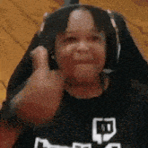 a child wearing headphones is giving a thumbs up .