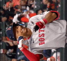 a baseball player wearing a boston jersey is smiling in front of a crowd