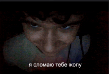 a man 's face is shown in a dark room with the words " я сломаю тебе жопу " in the corner