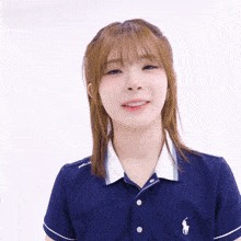a woman wearing a blue polo shirt with a white horse on the front