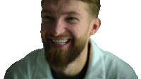 a man with a beard is smiling and wearing a lab coat