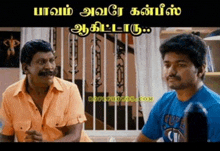 two men are sitting next to each other and one of them is wearing a blue shirt that says ' super ' on it