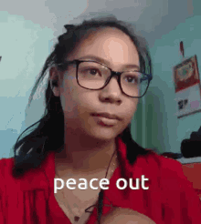 a girl wearing glasses and a red shirt has the words peace out written on her face