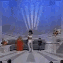 a group of people are dancing on a stage in a room .