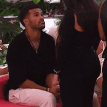 a man is sitting on a couch looking at a woman 's butt .