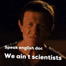 a man says " speak english doc we ain 't scientists " in front of a dark background