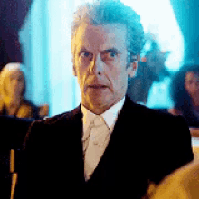 a man in a suit and tie is looking at something