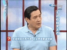 a man in a blue shirt has a question mark in front of him in chinese