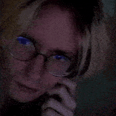 a close up of a person 's face with glasses and blue eyes
