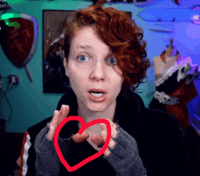 a woman with red hair has a red heart drawn around her neck