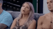 a woman is sitting on a couch next to a man .