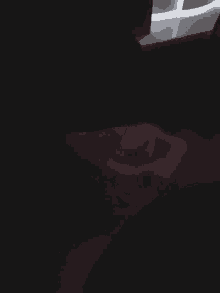 a close up of a person 's hand in a dark room with a red light behind them .