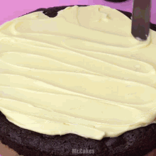 a chocolate cookie with white frosting and oreos on a pink surface