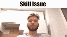 a man with a beard is looking at the camera with the words skill issue behind him