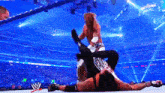 two wrestlers in a wrestling ring with a sign that says wrestlemania in the background