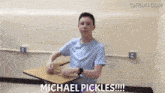 a young man sitting at a desk with the words michael pickles written on the bottom