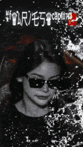 a black and white photo of a woman wearing sunglasses with the caption captured on the bottom