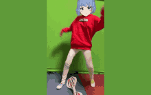 a girl in a red sweater with the word joker on it is standing in front of a green screen