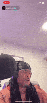 a man wearing headphones and a headband is singing into a microphone with the time of 3:41 on the screen