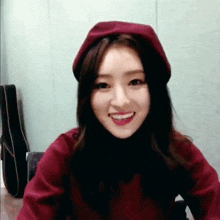a woman wearing a red beret and a red sweater smiles for the camera