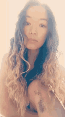 a woman with long curly hair and a tattoo on her leg