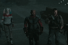 a woman in a harley quinn outfit is standing next to two men