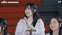 a girl applauds in front of a sign that says runup ..