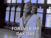 a man is singing a song in front of a window while wearing a white shirt and a necklace .