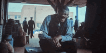 a man sits in front of a screen that says win on it