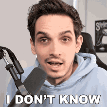 a man standing in front of a microphone with the words " i don 't know " below him