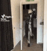 a man wearing a mask is walking through a doorway with a tiktok logo on the wall