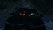 a man in a red hat sits in the driver 's seat of a black audi