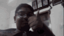 a man wearing glasses is taking a picture of himself in a living room .