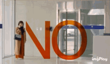 a woman is standing in front of a large no sign