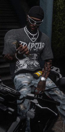 a man sitting on a motorcycle wearing a trapstar shirt