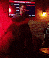 a man is dancing in front of a screen that says vibes karaoke w taurus on it