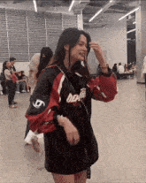 a woman wearing a red and black jacket that says death on it
