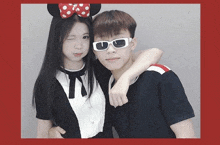 a girl wearing a minnie mouse headband and sunglasses stands next to a boy wearing sunglasses