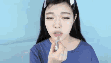a woman is applying lipstick to her lips with a brush .