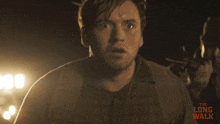 a man is holding a gun in front of a sign that says " the long walk "
