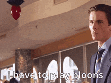 a man in a suit and tie is saying i have to play bloons