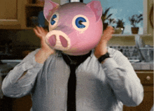 a man wears a pink pig mask on his face