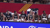 a group of female basketball players wearing france jerseys sit on the sidelines