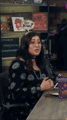 a woman sits at a table with a sign that says got beads