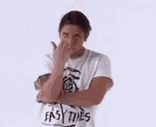 a man in a white t-shirt is making a funny face .
