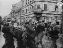 a black and white photo of a group of people walking down a street