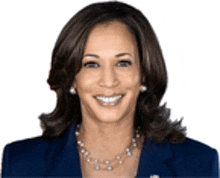 a woman wearing a blue jacket and a pearl necklace is smiling for the camera .